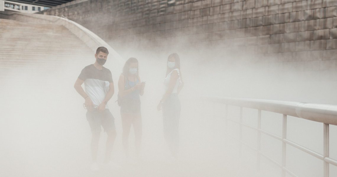 Three people with masks on a pollution cloud